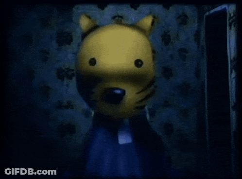 A Yellow Stuffed Animal With A Black Nose Is Standing In A Dark Room GIF