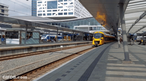 A Yellow Train At A Station With A Sign That Says ' Nsb ' On It GIF