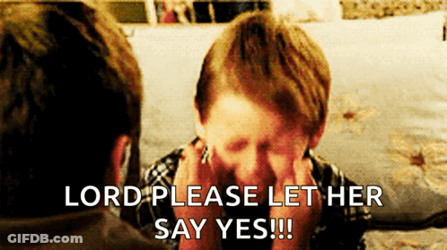 A Young Boy Covering His Face With His Hands While A Man Says Lord Please Let Her Say Yes !!! GIF