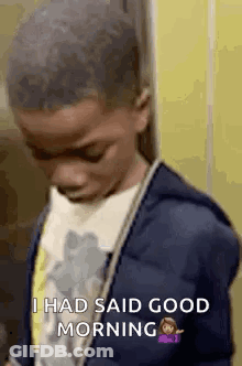 A Young Boy In A Blue Jacket Is Standing In Front Of A Yellow Wall And Says `` I Had Said Good Morning '' . GIF