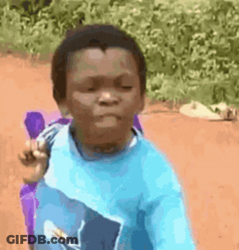 A Young Boy In A Blue Shirt Is Sitting On A Dirt Road With A Purple Backpack . GIF