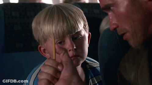 A Young Boy In A Blue Shirt Is Sitting On An Airplane GIF