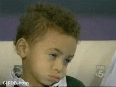 A Young Boy In A Bow Tie Is Making A Funny Face . GIF