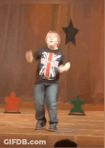 A Young Boy In A British Flag Shirt Is Jumping In The Air GIF