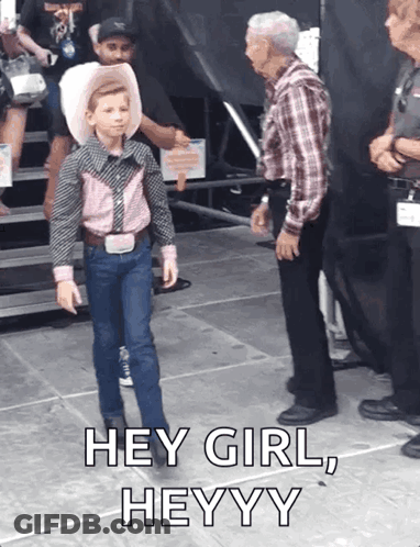 A Young Boy In A Cowboy Outfit Is Standing Next To An Older Man With The Caption Hey Girl Heyyy GIF