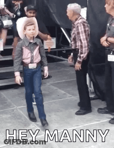 A Young Boy In A Cowboy Outfit Is Walking In Front Of A Man . GIF