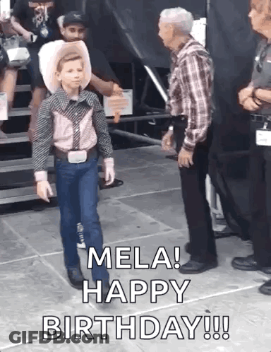 A Young Boy In A Cowboy Outfit Is Walking On A Stage While A Man Stands Behind Him And Says Mela Happy Birthday GIF
