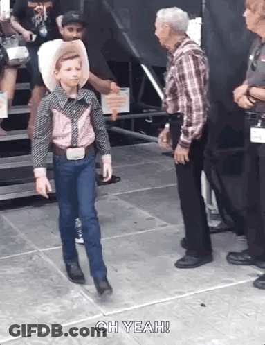 A Young Boy In A Cowboy Outfit Is Walking Towards An Older Man Who Says Oh Yeah . GIF