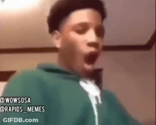 A Young Boy In A Green Hoodie Is Making A Surprised Face . GIF