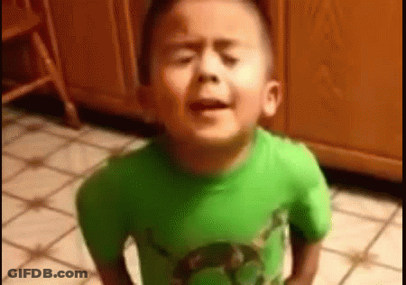 A Young Boy In A Green Shirt Is Standing On A Tiled Floor . GIF