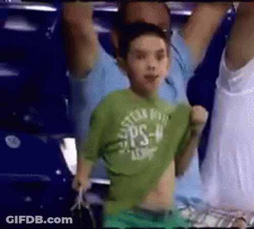A Young Boy In A Green Shirt With The Word Ps On It Is Dancing In A Crowd . GIF