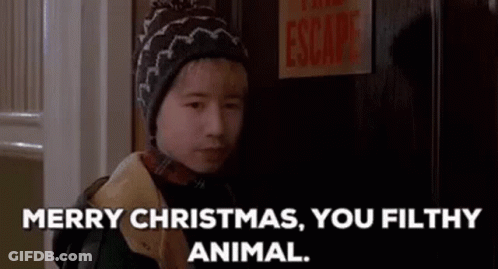 A Young Boy In A Hat Is Standing In Front Of A Door . GIF