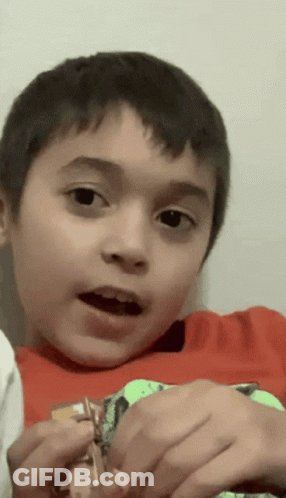 A Young Boy In A Red Shirt Is Holding A Toy GIF