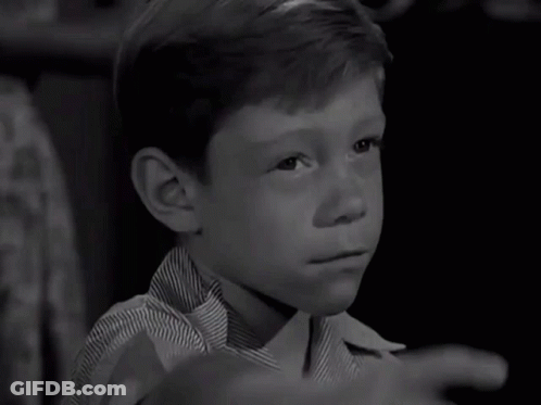 A Young Boy In A Striped Shirt Is Pointing His Finger GIF