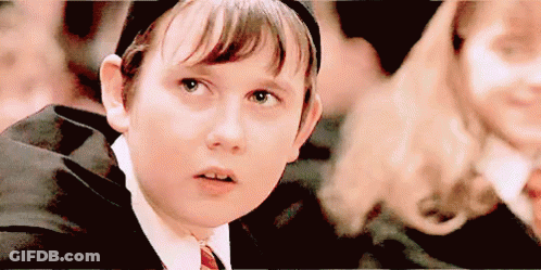 A Young Boy In A Suit And Tie Is Looking Up At Something . GIF