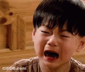 A Young Boy Is Crying With His Mouth Open In A Close Up Of His Face . GIF