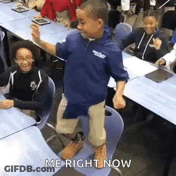 A Young Boy Is Dancing In A Classroom In Front Of A Group Of Students . GIF
