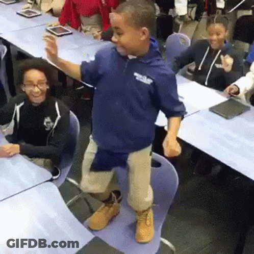 A Young Boy Is Dancing In A Classroom With Other Children . GIF