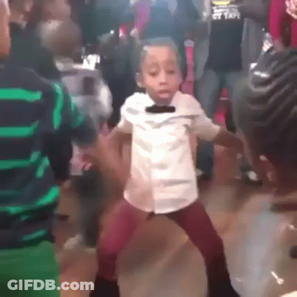 A Young Boy Is Dancing In A Crowd Of People . GIF