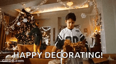 A Young Boy Is Decorating A Living Room For Christmas . GIF