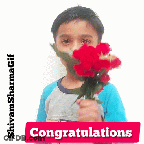 A Young Boy Is Holding A Bouquet Of Red Flowers In Front Of His Face With A Congratulations Sign Below Him GIF