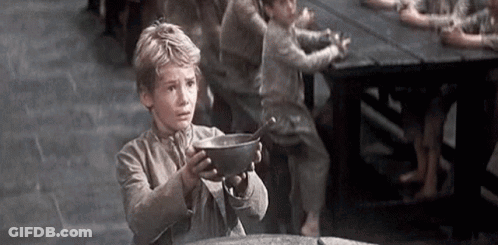 A Young Boy Is Holding A Bowl Of Food In His Hands . GIF