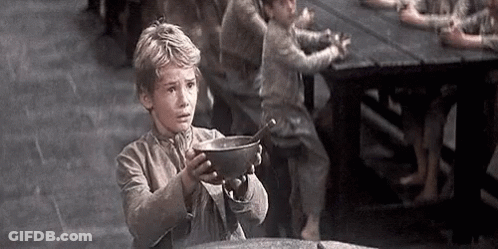 A Young Boy Is Holding A Bowl With A Spoon In It In Front Of A Group Of Children . GIF