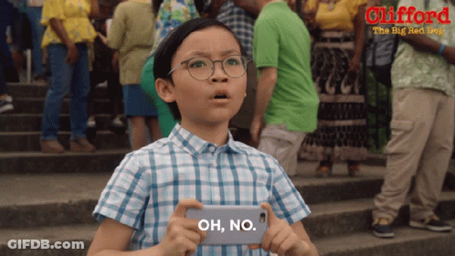 A Young Boy Is Holding A Cell Phone That Says Oh No On It GIF