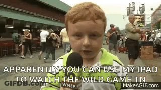 A Young Boy Is Holding A Microphone And Talking Into It While Standing In Front Of A Crowd . GIF