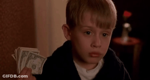 A Young Boy Is Holding A Stack Of Dollar Bills In His Hand . GIF