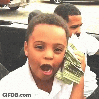 A Young Boy Is Holding A Stack Of Money In Front Of His Face . GIF
