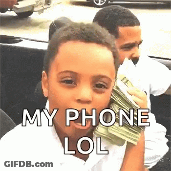 A Young Boy Is Holding A Stack Of Money In His Hand And Talking On A Cell Phone . GIF