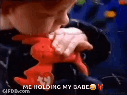 A Young Boy Is Holding A Stuffed Animal And Says Me Holding My Babe . GIF
