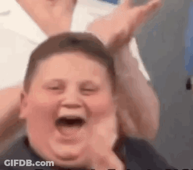 A Young Boy Is Laughing With His Mouth Open While Being Held By A Person . GIF