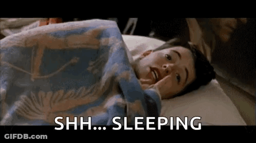 A Young Boy Is Laying In Bed Under A Blanket With The Words `` Shh ... Sleeping '' . GIF