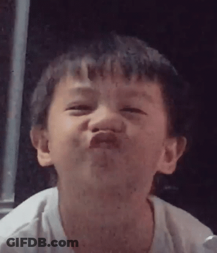 A Young Boy Is Making A Funny Face And Making A Funny Face With His Mouth Open . GIF