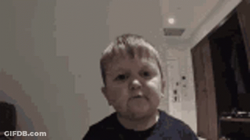A Young Boy Is Making A Funny Face While Looking At The Camera . GIF