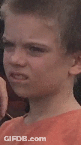 A Young Boy Is Making A Funny Face While Looking At The Camera . GIF