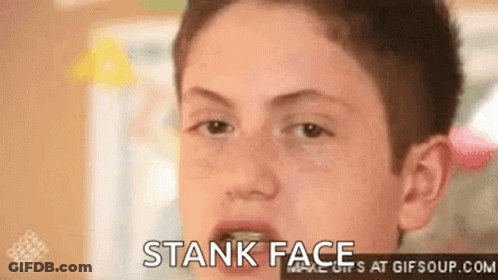 A Young Boy Is Making A Funny Face With His Mouth Open And The Words Stank Face At The Bottom . GIF