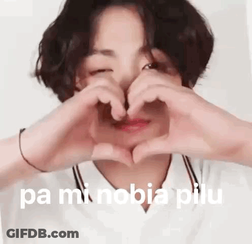 A Young Boy Is Making A Heart Shape With His Hands . GIF