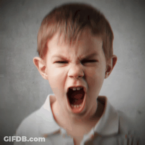 A Young Boy Is Making A Very Angry Face With His Mouth Open GIF