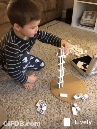 A Young Boy Is Playing A Game Of Dominoes On The Floor With The Word Lively In The Corner GIF