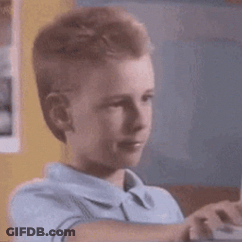 A Young Boy Is Playing A Video Game On A Computer While Looking At The Screen . GIF