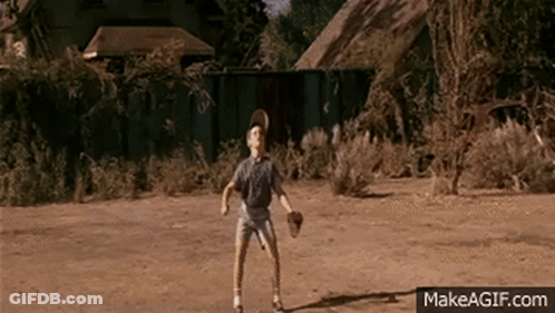 A Young Boy Is Playing Baseball In A Dirt Field With Makeagif.com Written On The Bottom Of The Screen GIF