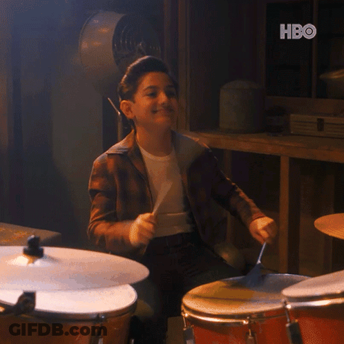 A Young Boy Is Playing Drums With A Hbo Logo In The Background GIF