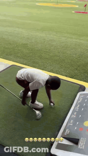 A Young Boy Is Playing Golf On A Driving Range . GIF