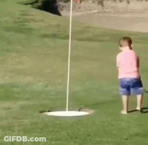 A Young Boy Is Playing Golf On A Green GIF