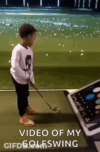 A Young Boy Is Playing Golf With A Video Of His Golf Swing In The Background GIF
