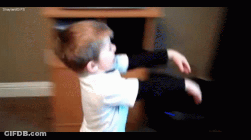 A Young Boy Is Playing With A Remote Control In Front Of A Tv .. GIF