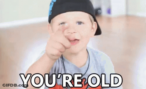 A Young Boy Is Pointing At The Camera With The Words `` You 'Re Old '' Written Below Him . GIF